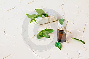 Peppermint essential oil in a glass bottle on a light table. Used in medicine, cosmetics and aromatherapy