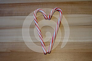 Peppermint flavored candy cane treats in a heart shape c on a wooden board