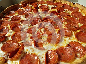 Pepperoni pizza in cardboard box with grease