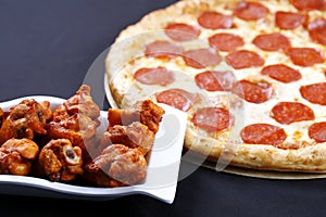 Pepperoni pizza with chicken wings