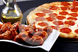 Pepperoni pizza with chicken wings
