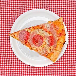 Pepperoni pizza slice on white plate