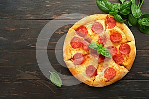 Pepperoni pizza. Traditional pepperoni pizza and cooking ingredients tomatoes basil on wooden table backgrounds. Italian
