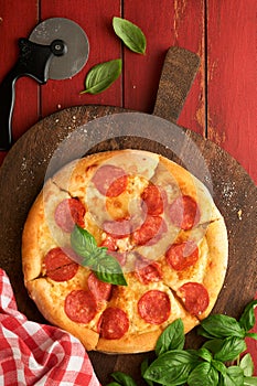 Pepperoni pizza. Traditional pepperoni pizza and cooking ingredients tomatoes basil on wooden table backgrounds. Italian