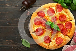 Pepperoni pizza. Traditional pepperoni pizza and cooking ingredients tomatoes basil on wooden table backgrounds. Italian