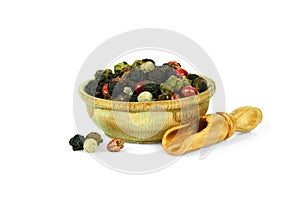 Peppers mix in a wooden cup with a spoon for spices isolated on a white background. Collection of spices and herbs