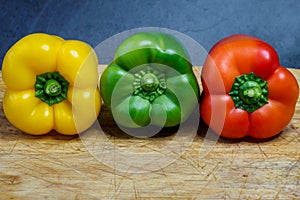 Peppers in three colours on a kitchen breadboard