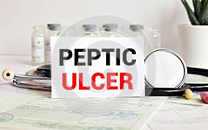 Peptic ulcer - diagnosis written on a white piece of paper. Syringe and vaccine with drugs