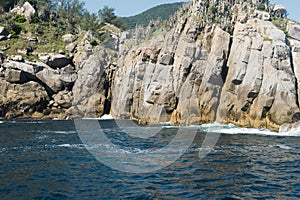 Beautiful landscape by the sea, with rocky mountains, vegetation and waves. photo
