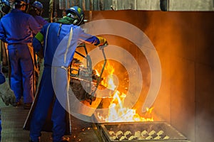 perator pouring molten metal in automatic casting line in foundry factory photo