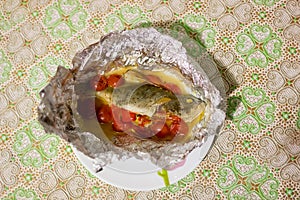 perch baked with vegetables in foil on a platter