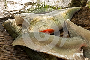 Perch fish fillets on a wooden filleting board photo