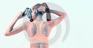 Percussion massager, young female massaging shoulder in neon studio light, therapy for joint pain relief, back view