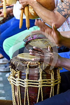 Percussionist playing a rustic and rudimentary percursion instrument atabaque photo