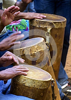 Percussionists group playing a rudimentary atabaque made with leather and wood