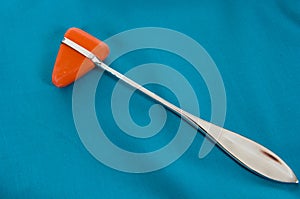 Percussive reflex hammer on green surgical scrub background