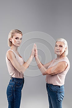 Peremptory young lady and old grey-haired woman raising hands