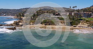 Perfect aerial wide shot of a Malibu California beach with white water waves crashing on the sand from a helicopter point of view