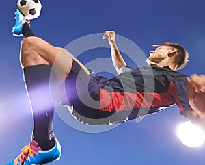 The perfect bicycle kick. a young footballer kicking a ball in mid-air.