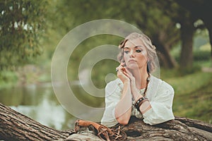 Perfect blonde model woman in boho style dress at the lake outdoor