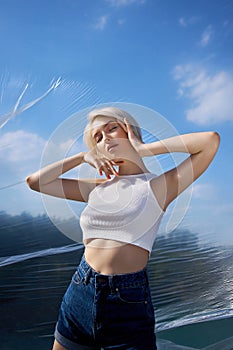 Perfect blonde woman short hair. Fashion woman poses in summer in nature on a sunny day. Red nail manicure