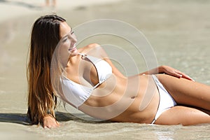 Perfect body of a woman in bikini lying on the beach photo