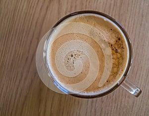 A top down view of an inviting glass mug of fresh coffee on a table