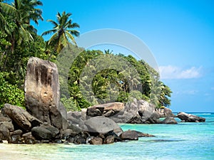 Perfect day on rocky Seychelles beach with blue skies