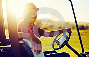 The perfect day to be on the fairway. Portrait of a happy young man driving a cart on a golf course.