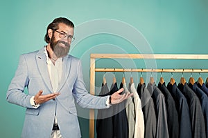 perfect design. tailor man has fashionable look. Elegant suits hang in row. Mens clothes on hanger. mature man looking