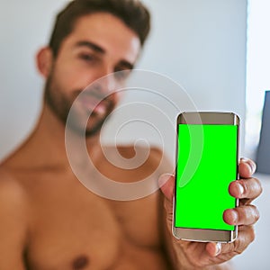 The perfect display for anything you want to show. a handsome young man holding a cellphone with a green screen display