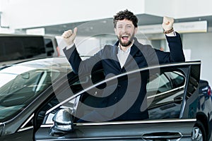 The perfect drive. Male customer looking emotional and excited choosing a car at the car dealership