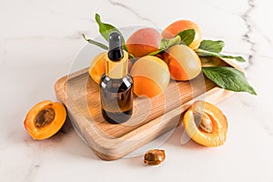 the perfect facial skin care product. apricot kernel oil in a cosmetic bottle with a pipette on a wooden tray and a