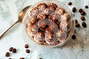 Perfect freshly made Italian tiramisu with cacao. Tiramisu portion on a white marble background. Delicious no bake tiramisu ready-