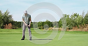 Perfect golf putt. Male golfer hitting ball and enjoying goal, playing outdoor at green course