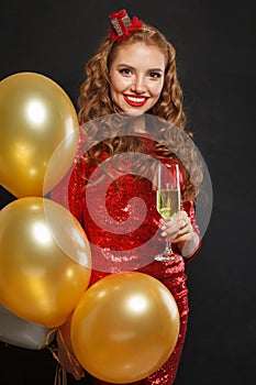 Perfect happy surprised woman with makeup and hairstyle wearing red shiny sequins dress holding party balloons, surprise, gifts