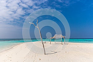 Perfect isolated island surrounded by a blue water sea, little hut, tree and blue sky day. Feeling of paradise, freedom, liberty.