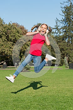 Perfect loud sound. Never ending joy. Girl listening music modern gadget. Kid happy with wireless headset dancing