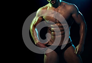 Perfect male muscular torso close up. Tanned skin and well built man. Strip theme and man wearing black underwear