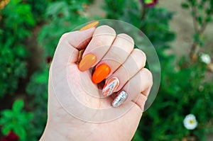 Perfect manicure and natural nails. Attractive modern nail art design. orange autumn design. long well-groomed nails