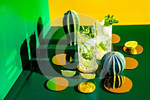 Perfect mojito cocktails on vintage colourful decor background and hard shadows