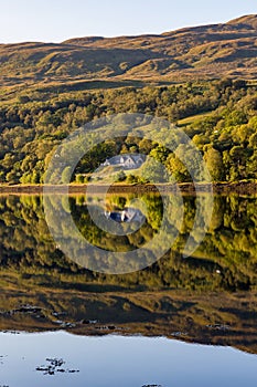 Perfect reflections on a beautiful Scottish Loch in the early morning sunshine Loch Eil, Fort William