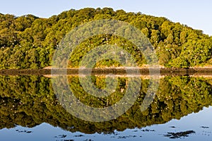 Perfect reflections on a beautiful Scottish Loch in the early morning sunshine Loch Eil, Fort William