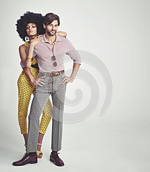 The perfect retro couple. An attractive young couple standing together in retro 70s clothing.