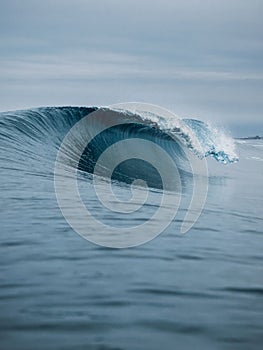 Perfect sea waves with blue water cloudy sky