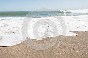 Perfect seascape. View from the shore to a hectic sea with white foam with a clear sunny blue sky. Summer day. Europe.