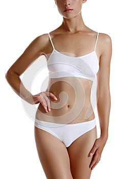 Perfect, slim, toned, young body of a girl in white underwear posing isolated on white. Plastic surgery and aesthetic