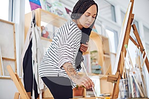 The perfect space to get creative. a beautiful young woman painting in a art studio.