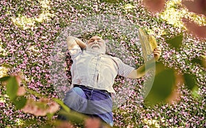 Perfect spring day. thinking about youth in park or garden. happy man under spring sakura blossom. senior man looking up