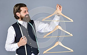 This is perfect. tailor man use tape measure. professional male sartor with measuring tape and hanger. Handsome man in photo